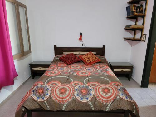 een bed met een deken en kussens erop bij El Remanso Estadia Minima 2 Noches in Cordoba