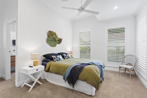 una camera da letto bianca con un letto e un ventilatore a soffitto di Sierra Cottage - A Homely Space, Superb Location a Toowoomba