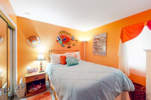 a bedroom with a large bed with orange walls at Plantation East #1104 in Gulf Highlands
