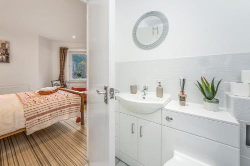 baño blanco con lavabo y cama en Spacious 3 Bedroom Modern House - Heart of Edinburgh - Private Main Door Entrance & Private Garden with Stunning Views of Arthur Seat, en Edimburgo