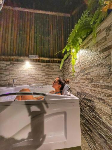 a woman sitting in a bath tub in a room at Ecohotel Piedemonte in Salento
