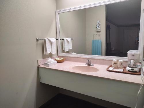 a bathroom with a sink and a large mirror at Hilltop Inn & Suites, near Foxwoods Casino in North Stonington