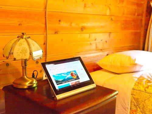 a laptop computer sitting on a table next to a bed at Pension Buddy in Kitashiobara