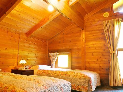 北塩原村的住宿－兄弟賓館，小木屋内一间卧室,配有两张床