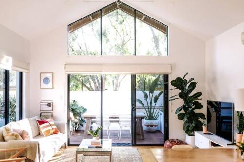 a living room with a couch and a large window at The Villa Margaret River in Margaret River Town