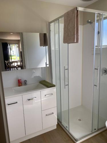 a white bathroom with a shower and a sink at Bundalong Riverside Resort in Bundalong