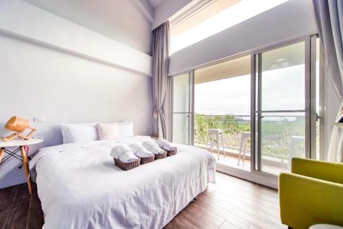 a bedroom with a bed and a large window at Miinnon Village B&B in Meinong