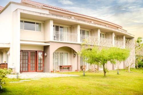 a house with a green yard in front of it at Miinnon Village B&B in Meinong