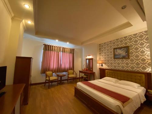 a hotel room with a bed and a table and chairs at Hoang Yen Hotel in Thuan An