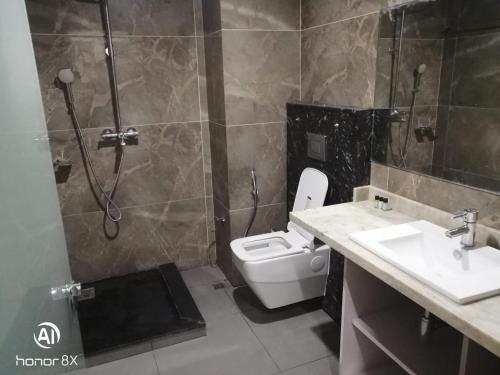 a bathroom with a shower and a toilet and a sink at The Jamun Tree in Muzaffarpur