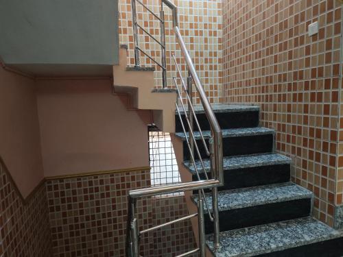 a staircase in a building with a metal railing at Vidya Guest House in Katra