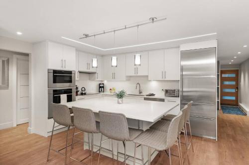 a white kitchen with a large white table and chairs at 700 Monarch 104 in Aspen