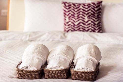 a pair of shoes in baskets on a bed at Miinnon Village B&B in Meinong