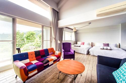a room with a couch and a bed and a table at Miinnon Village B&B in Meinong