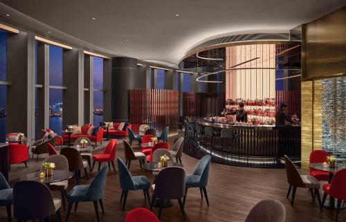 a restaurant with tables and chairs and a bar at Niccolo Suzhou in Suzhou