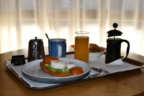 un piatto con un panino su un vassoio con una bevanda di The Town House Motor Inn a Goondiwindi