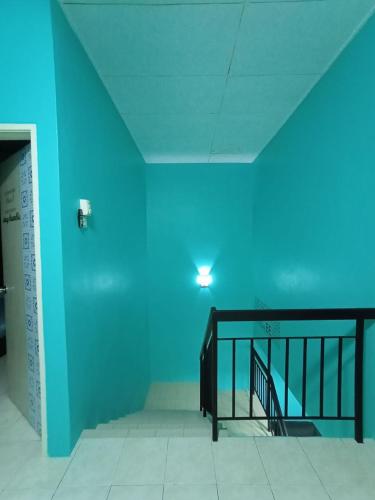 a blue room with a staircase and a blue wall at The Handz House II with WIFI - For family or same gender only in Kepala Batas