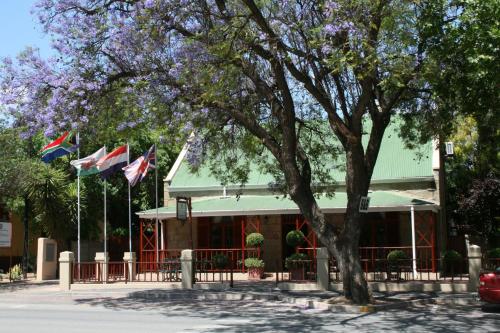 a building with two flags in front of it at 88 Baron van Reede Guesthouse in Oudtshoorn
