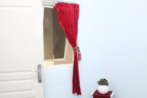a red curtain hanging out of a door at RedDoorz Syariah near Suncity Mall Madiun in Madiun