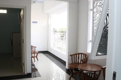 a hallway with chairs and a table and a window at RedDoorz Syariah near Suncity Mall Madiun in Madiun