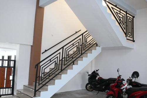 a group of motorcycles parked next to a staircase at RedDoorz Syariah near Suncity Mall Madiun in Madiun