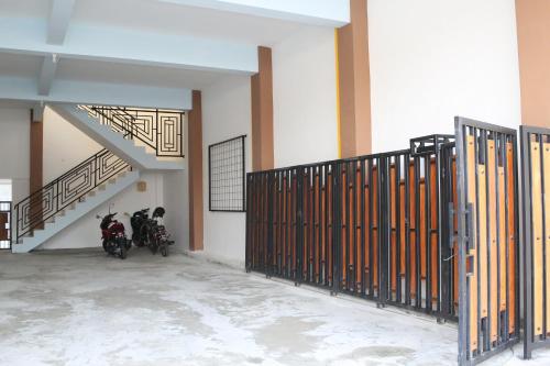 two motorcycles parked in a room with a staircase at RedDoorz Syariah near Suncity Mall Madiun in Madiun