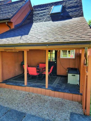 a screened in porch of a house with red chairs at The Davis Loft in Davis