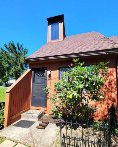 a brown house with a black door and a tree at The Davis Loft in Davis