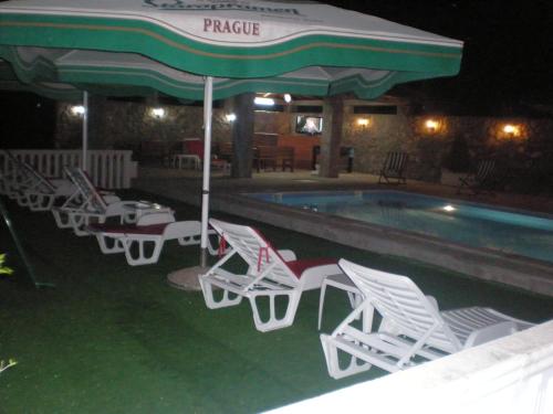 a swimming pool with chairs and an umbrella and a swimming pool at Apartments Vila Lazarevic in Tivat