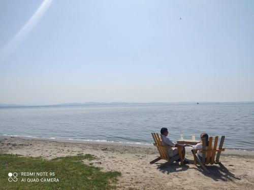 a man and woman sitting in chairs on the beach at depto relajante Diamante in Acapulco