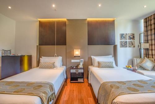 a hotel room with two beds and a couch at Vivanta Colombo, Airport Garden in Negombo