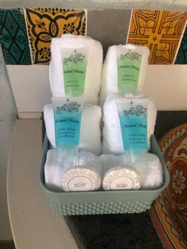 a basket of towels and toilet paper and towels at אלרון - אירוח בגולן in Ani'am