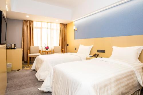 a hotel room with two beds with white sheets at Fu Hua Hotel in Macau