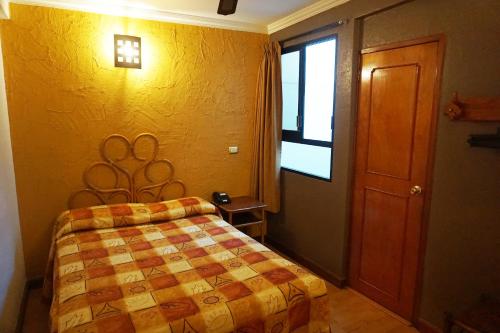 a bedroom with a bed and a window and a door at Hotel Plaza Crystal in Xalapa
