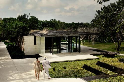 two people walking in front of a building at Alila Villas Uluwatu in Uluwatu
