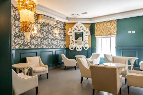 a dining room with green walls and white chairs and tables at Grand Daddy Boutique Hotel in Cape Town