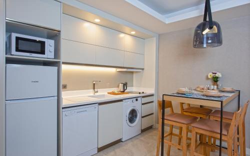 a kitchen with white appliances and a table with chairs at A Suite Side in Side