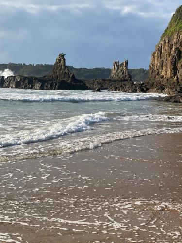 a beach with waves and rocks in the water at Paradise on Jones Beach Kiama - Beachfront unit with direct beach access & views in Kiama Downs