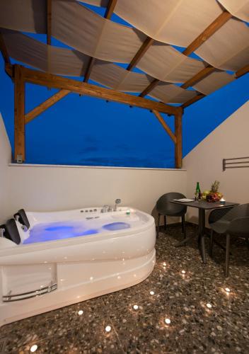 a bath tub in a room with a table at A Suite Side in Side