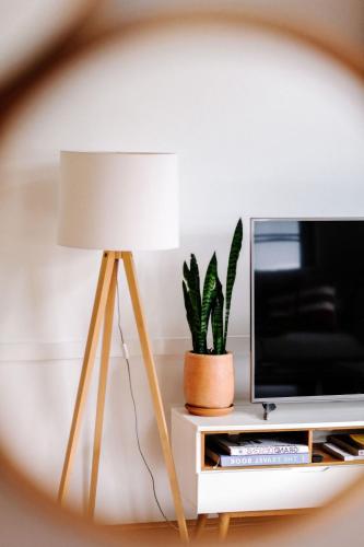 a table with a lamp and a tv and a plant at The Villa Margaret River in Margaret River Town