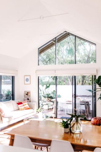 a living room with a large window and a table at The Villa Margaret River in Margaret River Town