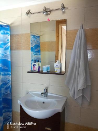 a bathroom with a sink and a mirror and a towel at Sardinia lux house in Sardínia