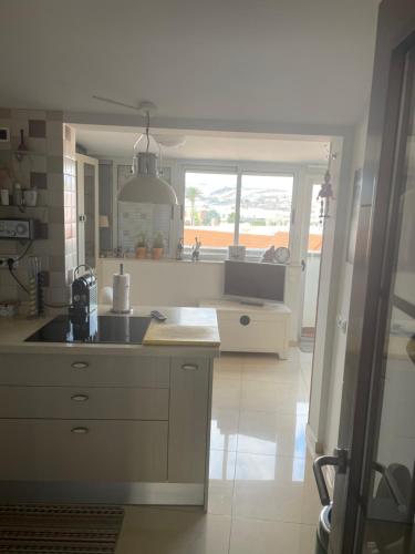 eine große Küche mit einem Waschbecken und einem Fenster in der Unterkunft Atico acogedor con vistas in Telde