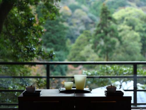 a table with two cups sitting on top of a window at Oku Yugawara Tsubaki in Yugawara