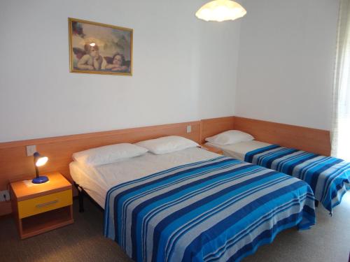 een slaapkamer met 2 bedden en een foto aan de muur bij Sea view flat just 70m from the beach in Porto Santa Margherita di Caorle