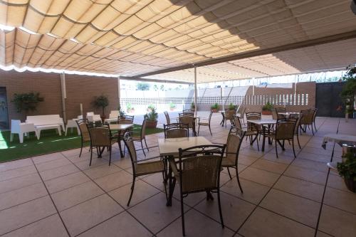 
a dining area with tables and chairs and umbrellas at Sercotel Gran Fama in Almería
