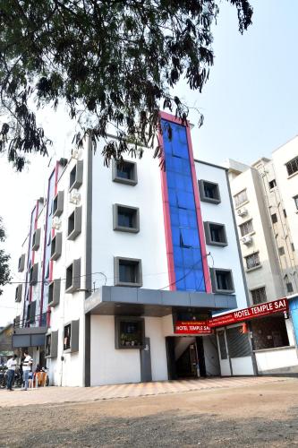 a white building with a red and blue at Hotel Temple Sai in Shirdi