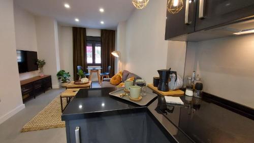 a kitchen with a counter top and a living room at Apartamento Golddem City in Málaga