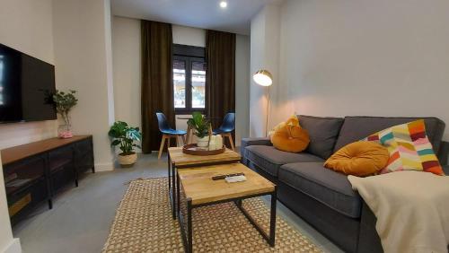 - un salon avec un canapé et une table dans l'établissement Apartamento Golddem City, à Malaga