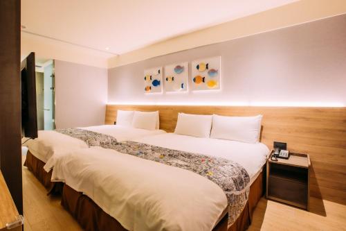 a hotel room with two beds in a room at Mega Hotel in Chiayi City
